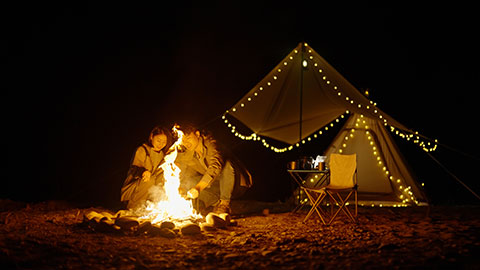 Happy young Chinese couple camping outdoors