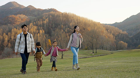 Happy young Chinese family hiking outdoors