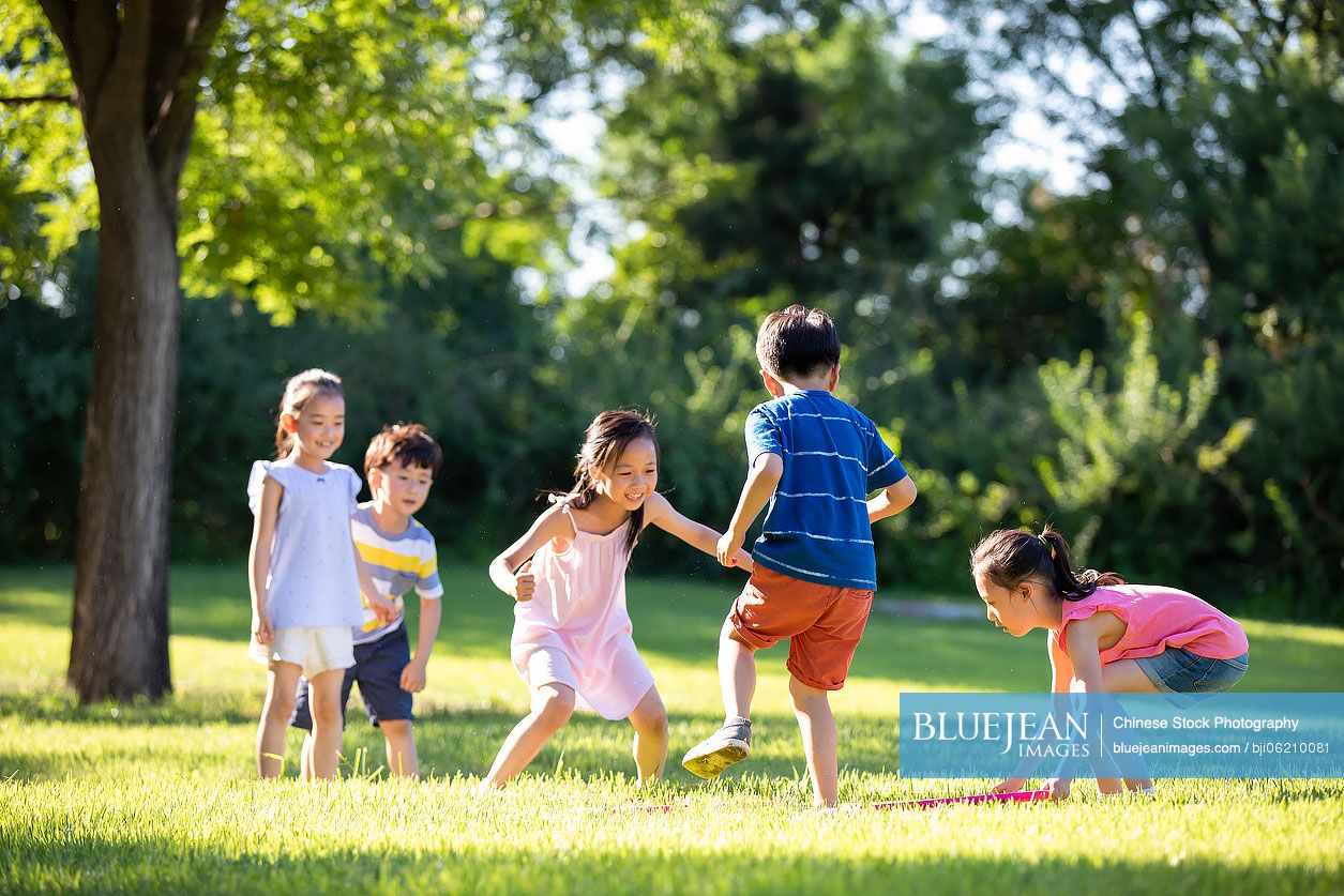 Happy Chinese children playing on meadow