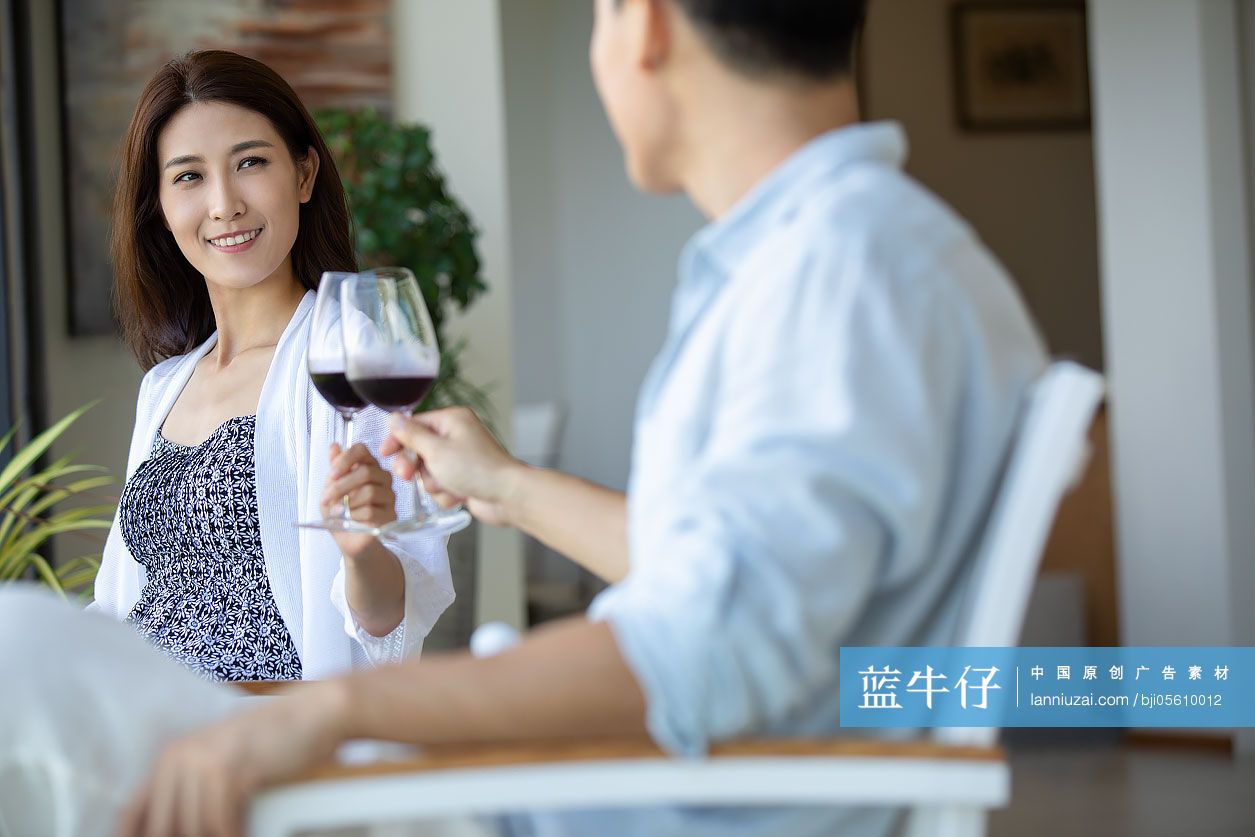 年轻夫妇在露台喝红酒