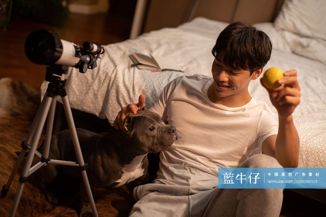 年轻男士和宠物狗在家玩耍