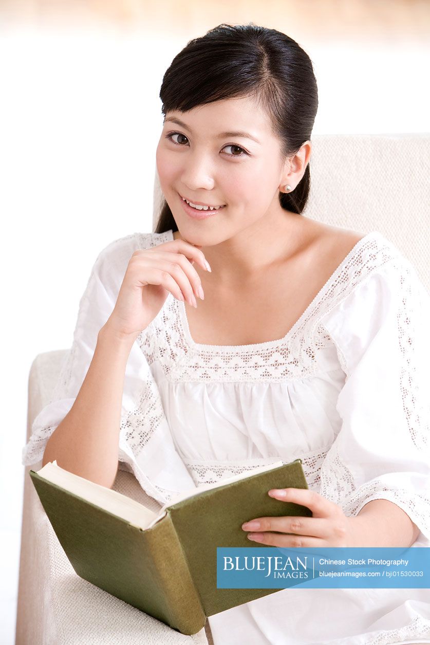 Chinese woman reading on a sofa