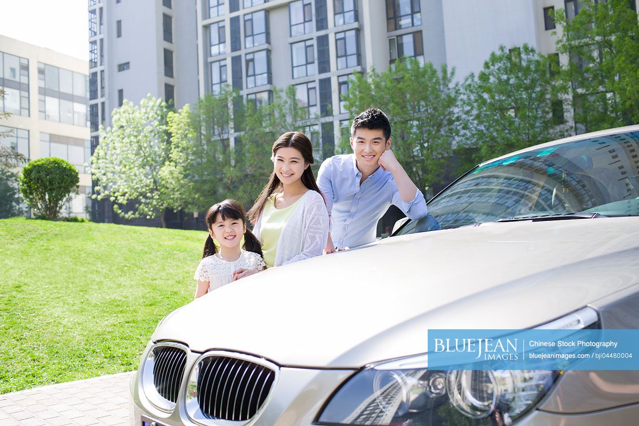 Happy young Chinese family and car