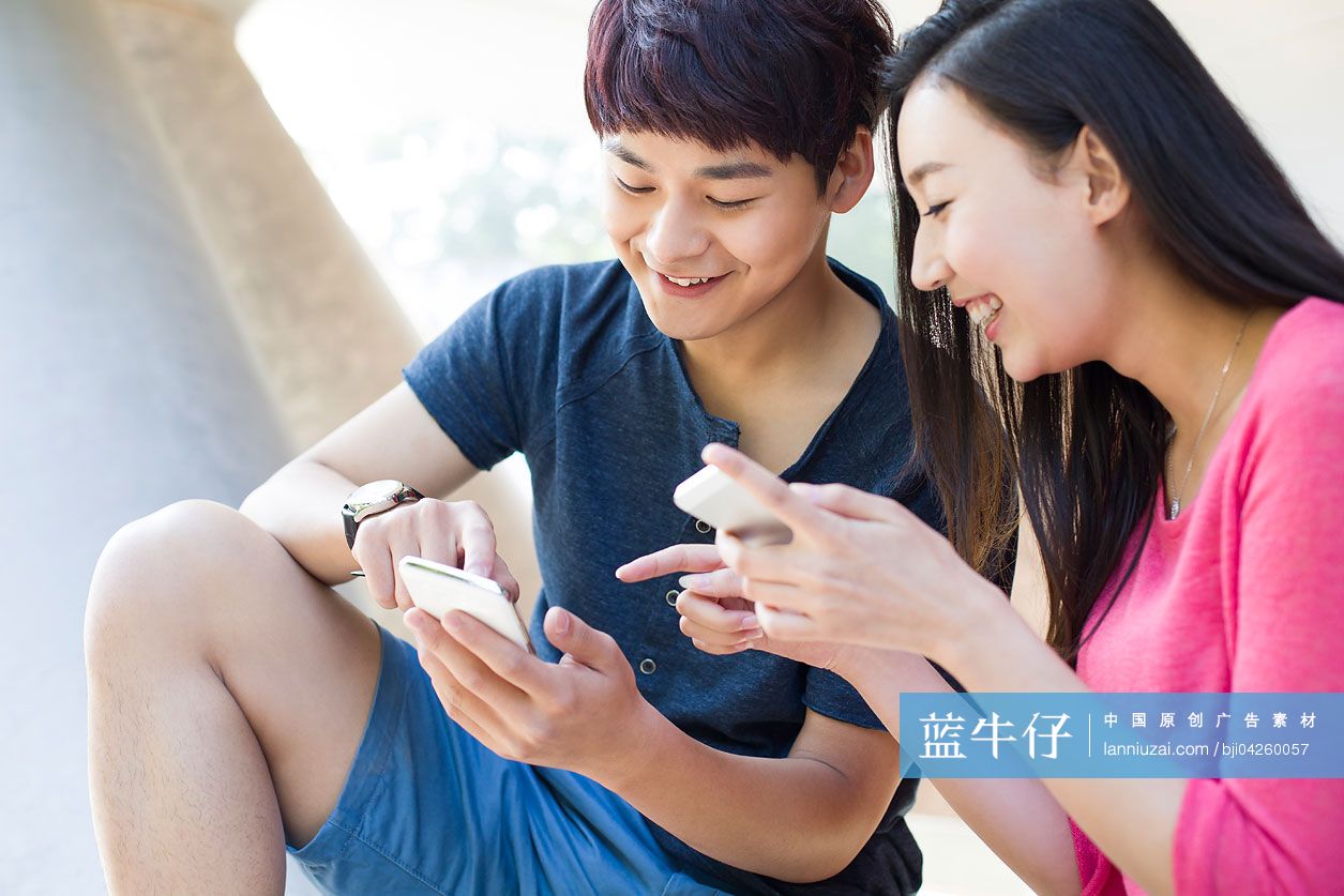 年轻情侣盯着手机看