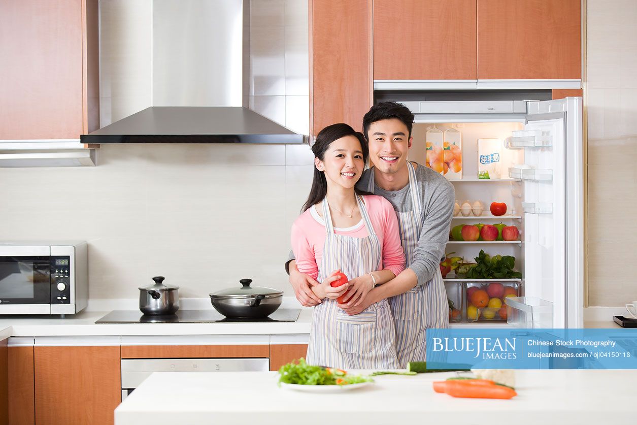 Happy young Chinese couple preparing meal