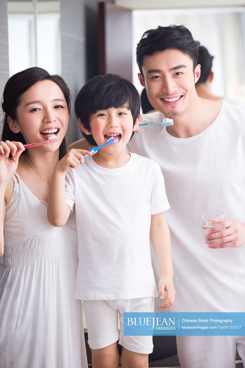 Happy Chinese family brushing teeth