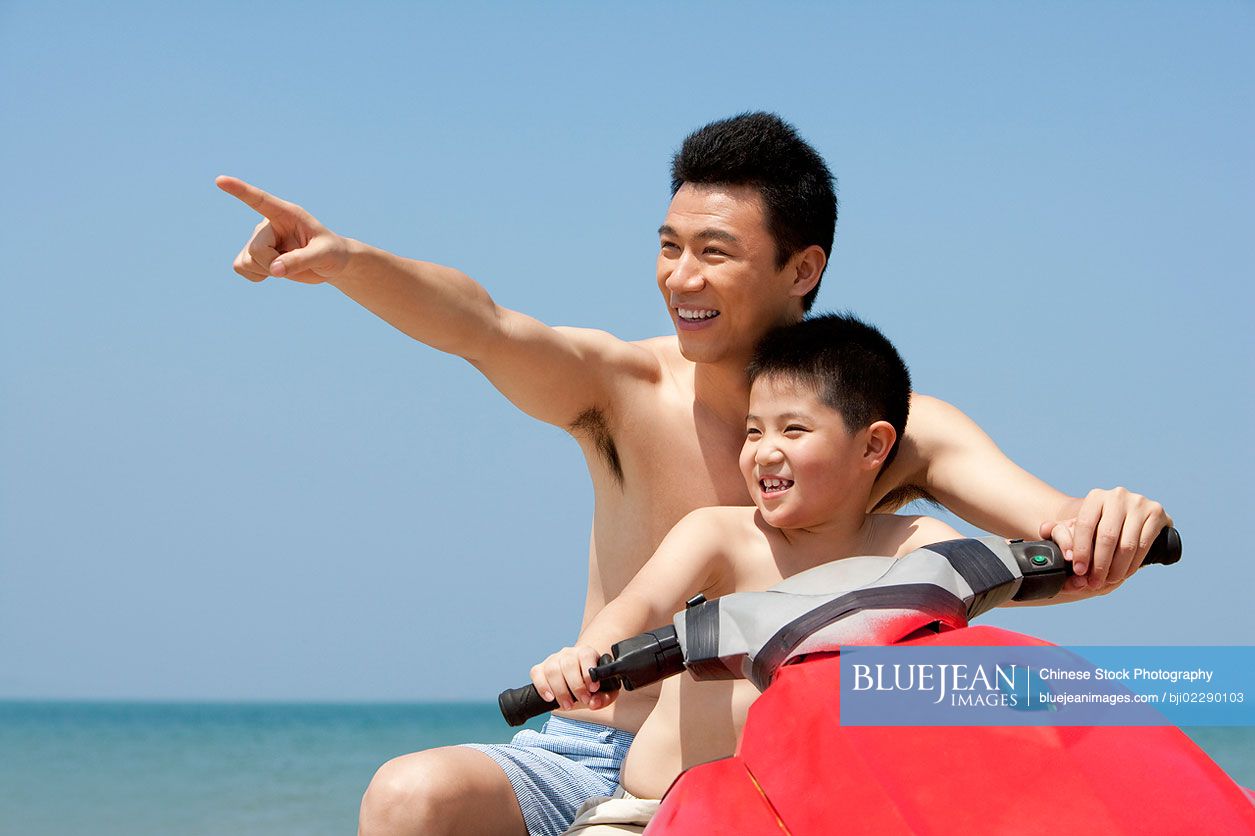 chinese-father-and-son-riding-on-a-jet-ski-high-res-stock-photo-for
