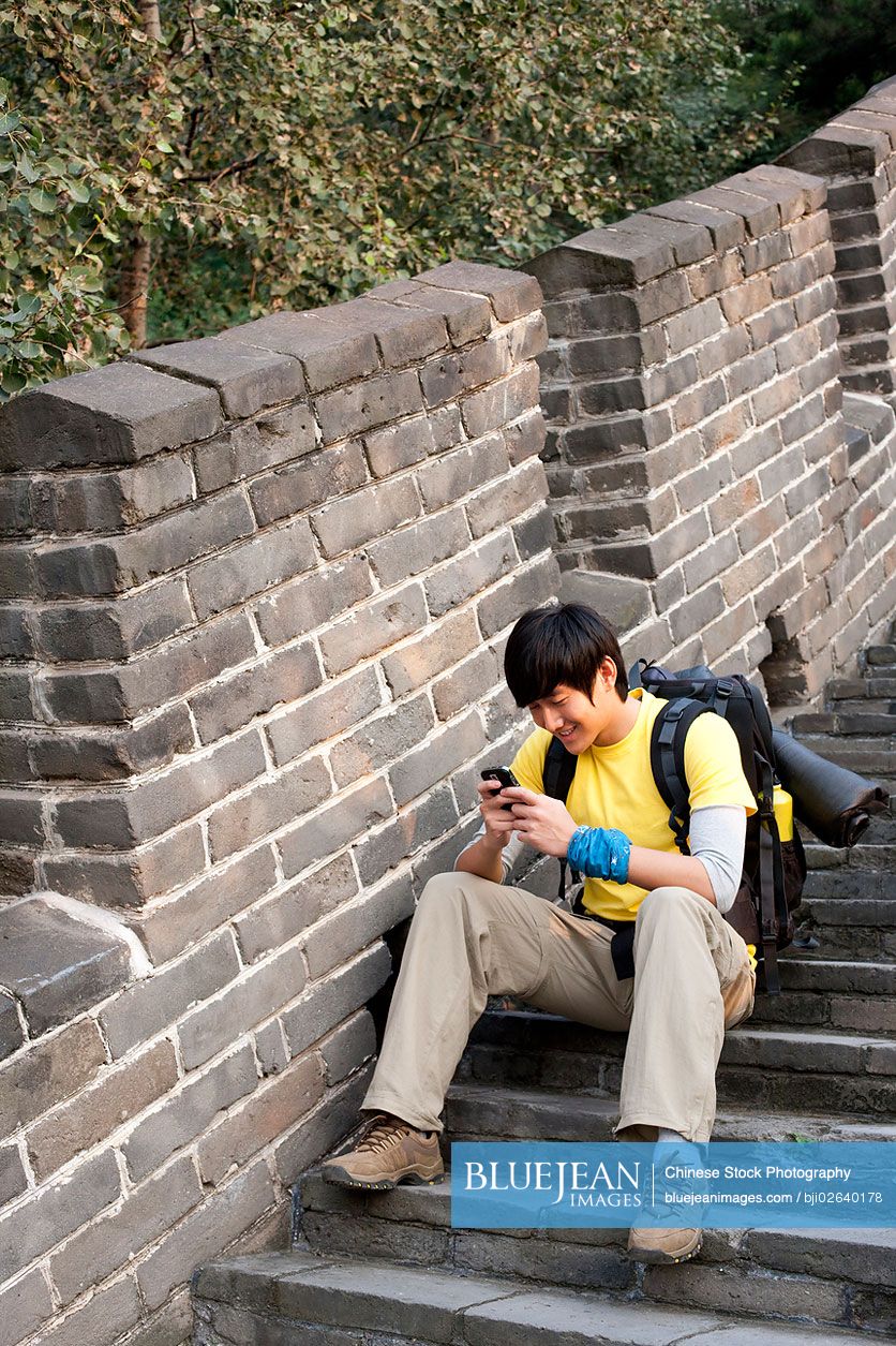 Young Chinese using cellphone on the Great Wall