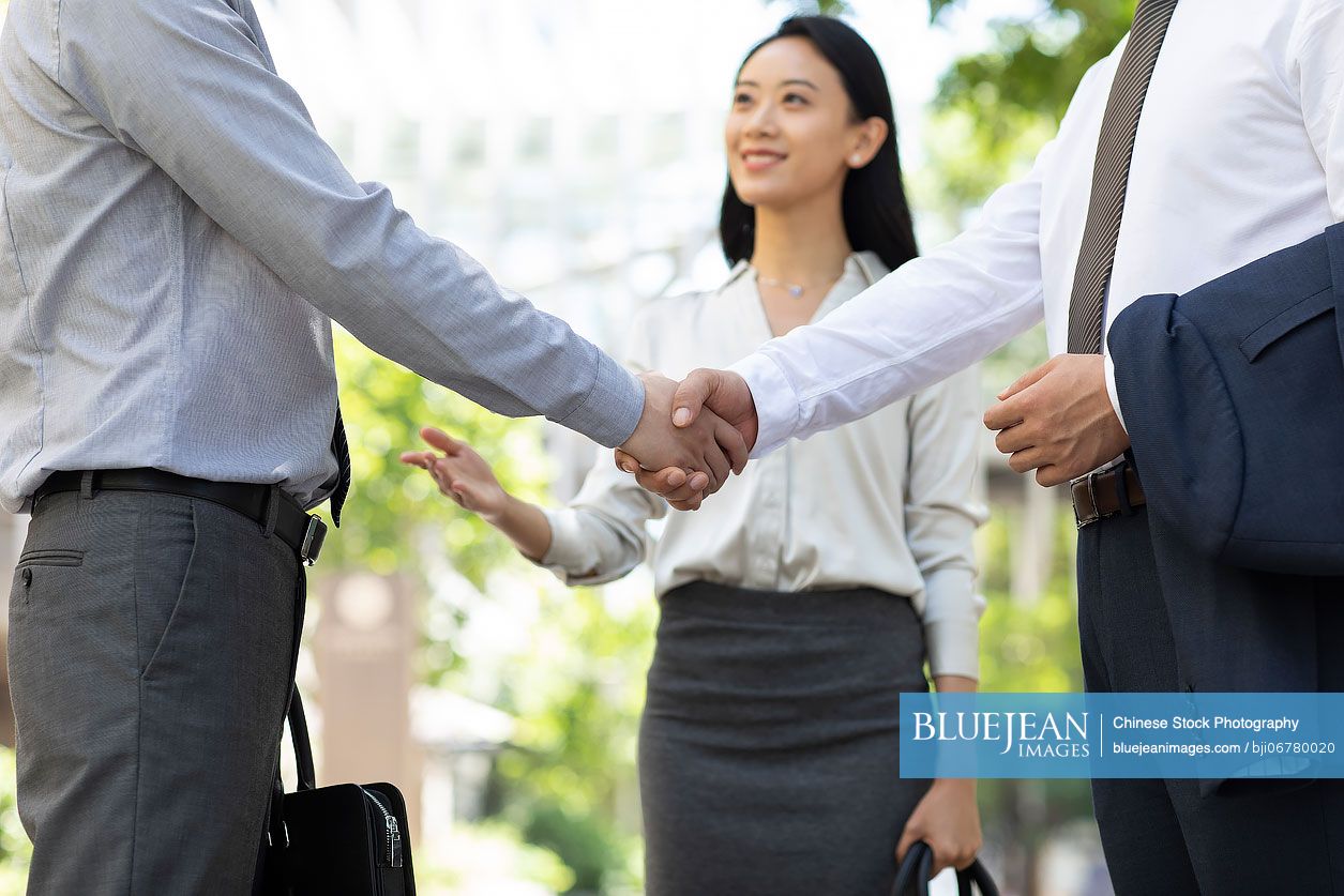 Cheerful Chinese business people having a meeting outdoors