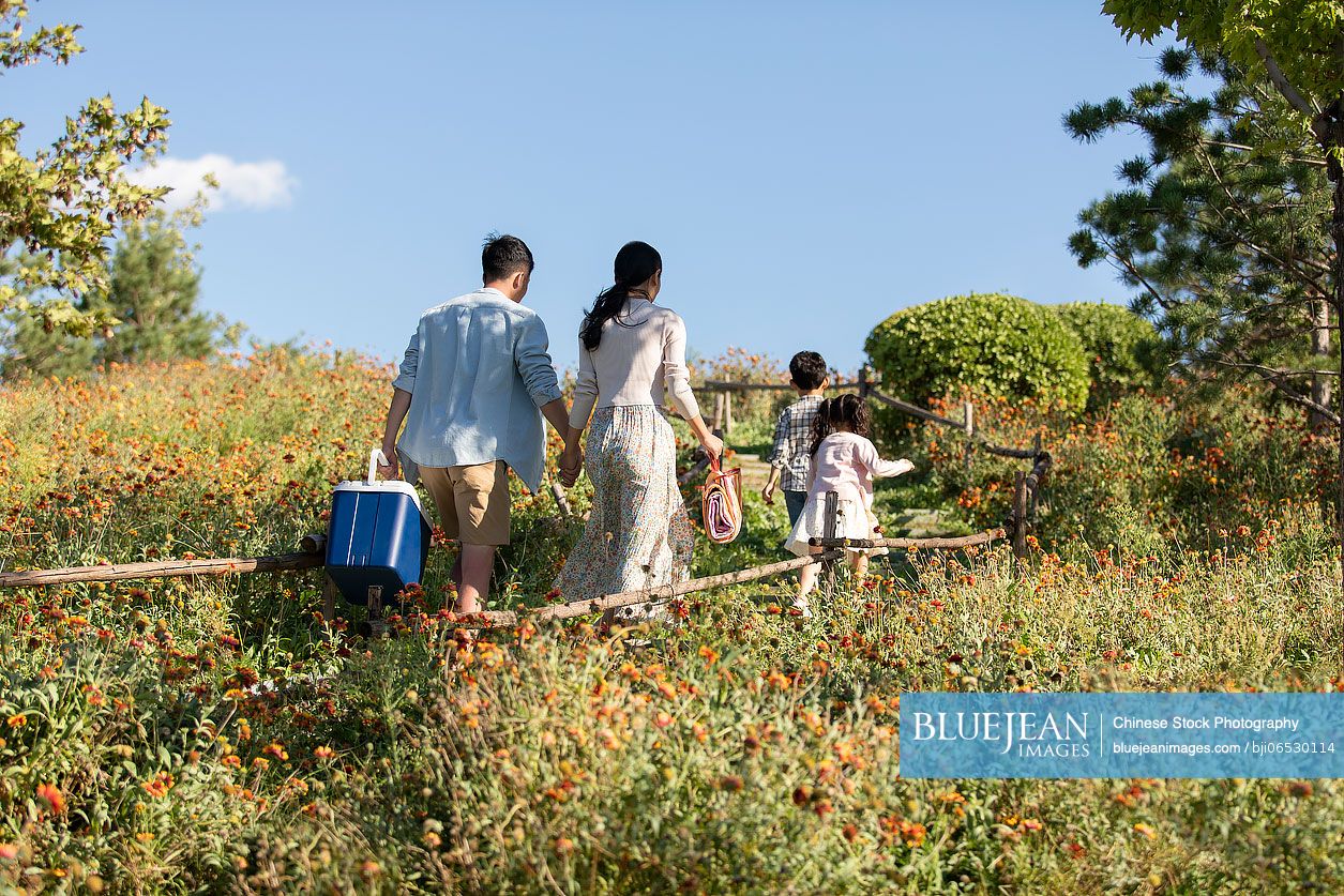 Happy young Chinese family relaxing in park