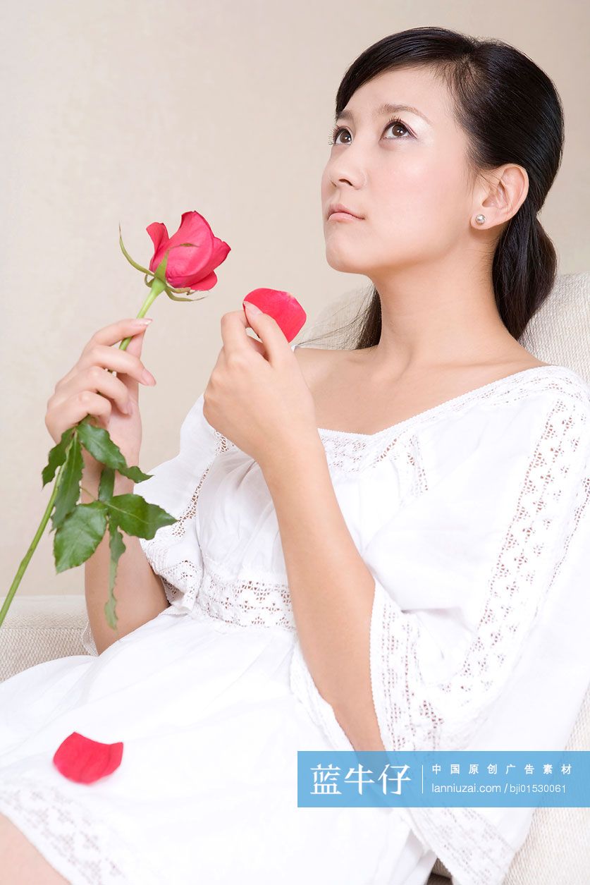 手拿玫瑰的年轻女子