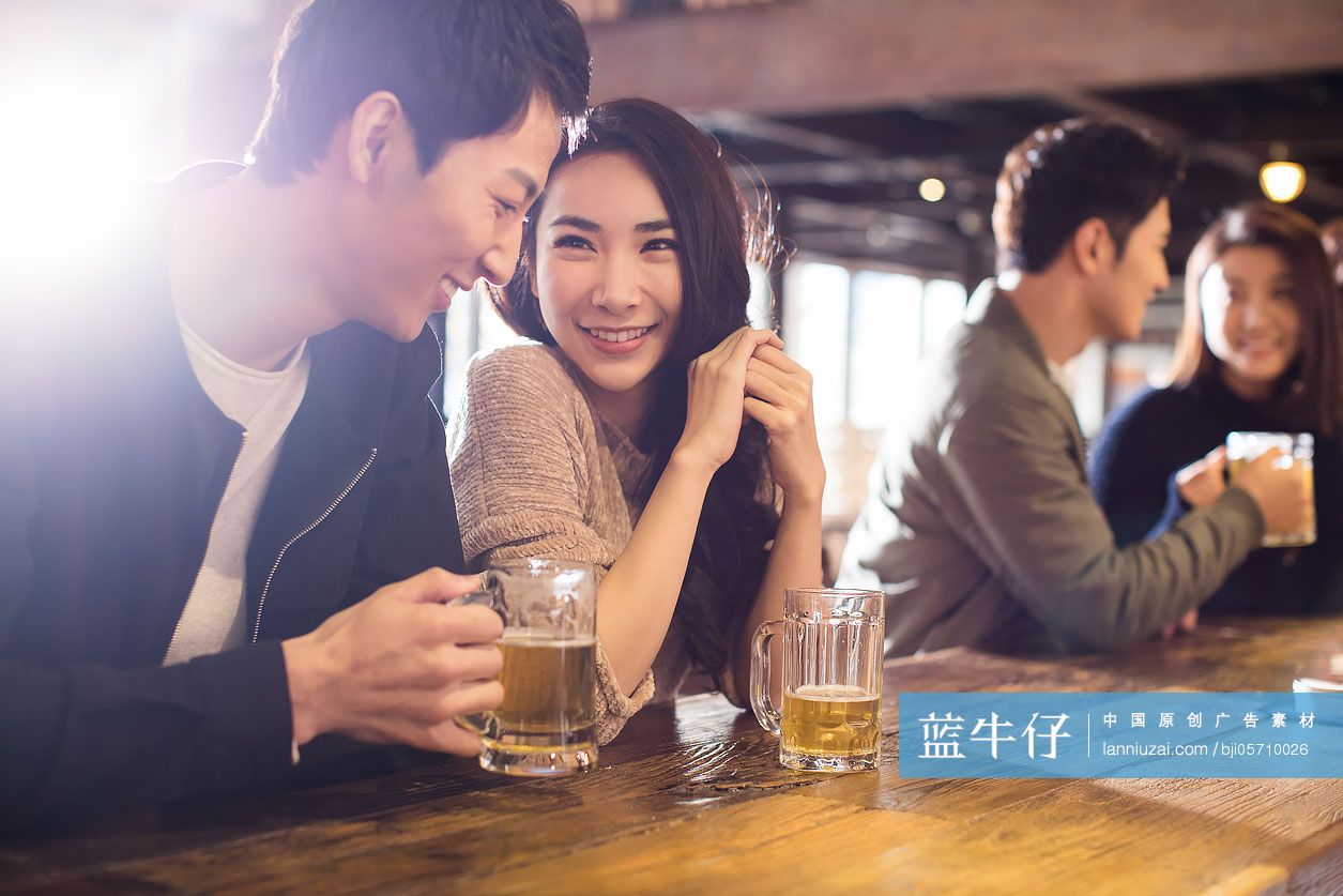 快乐的年轻情侣在酒吧喝酒聊天