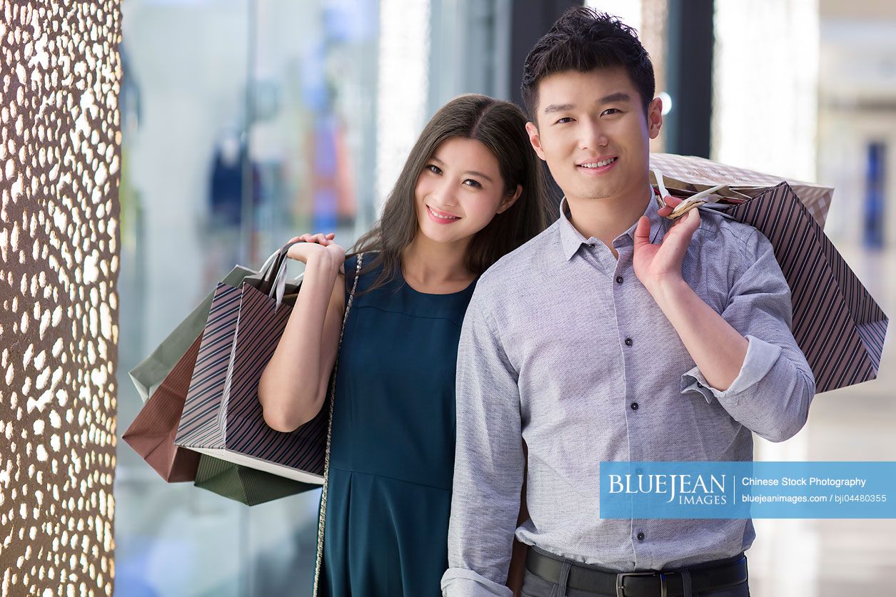 Happy young Chinese couple shopping