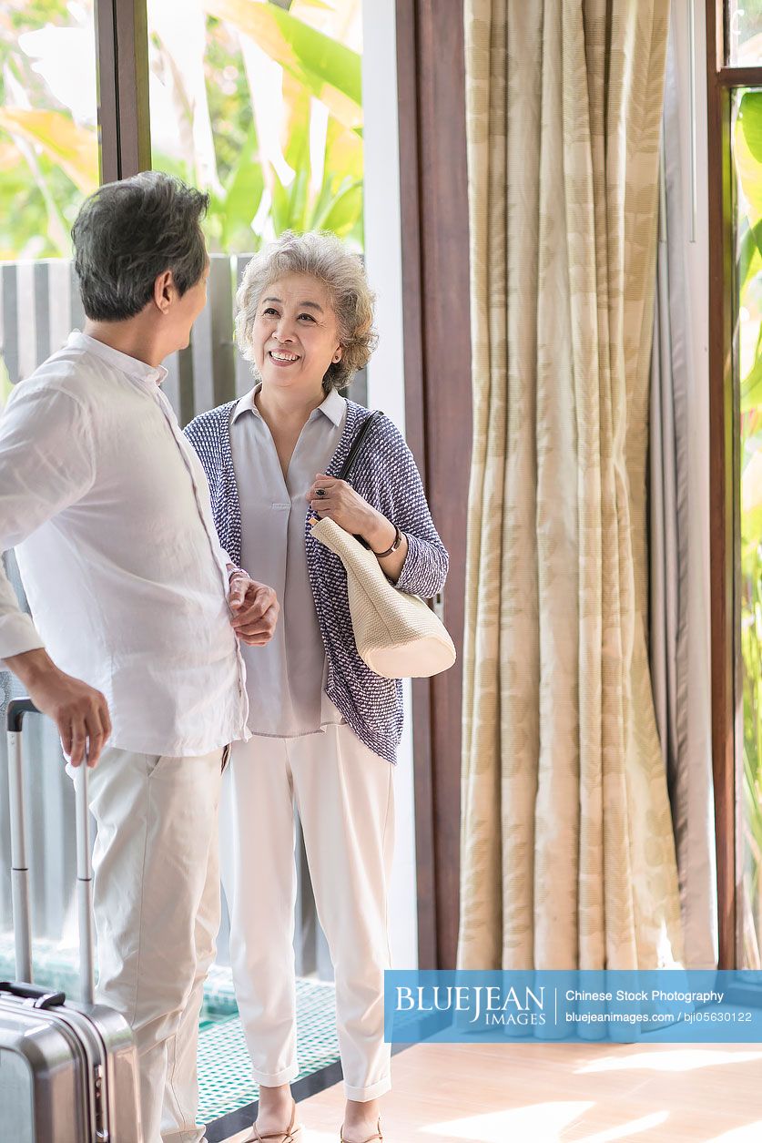 Happy senior Chinese couple in hotel room