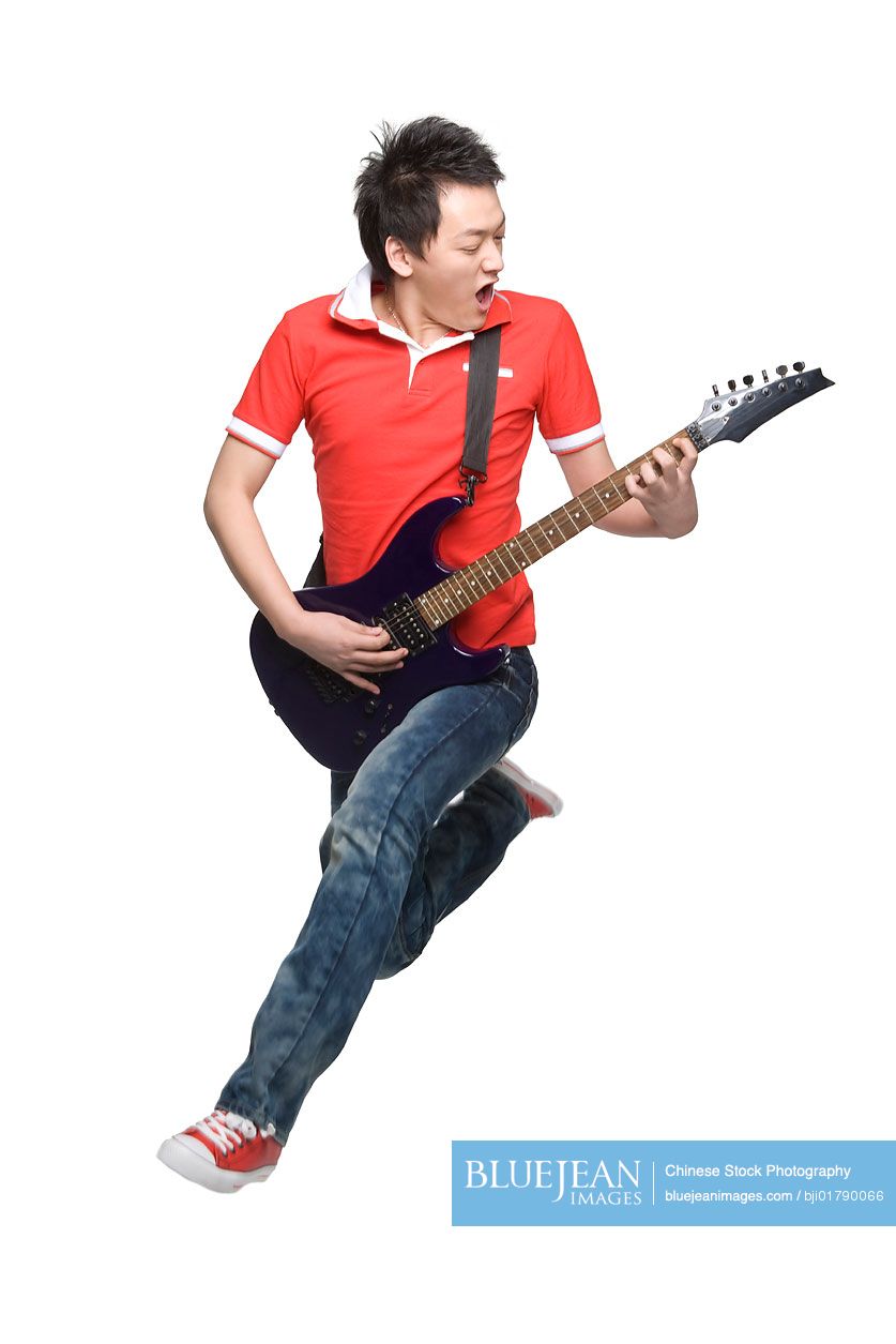 Young Chinese man playing an electric guitar