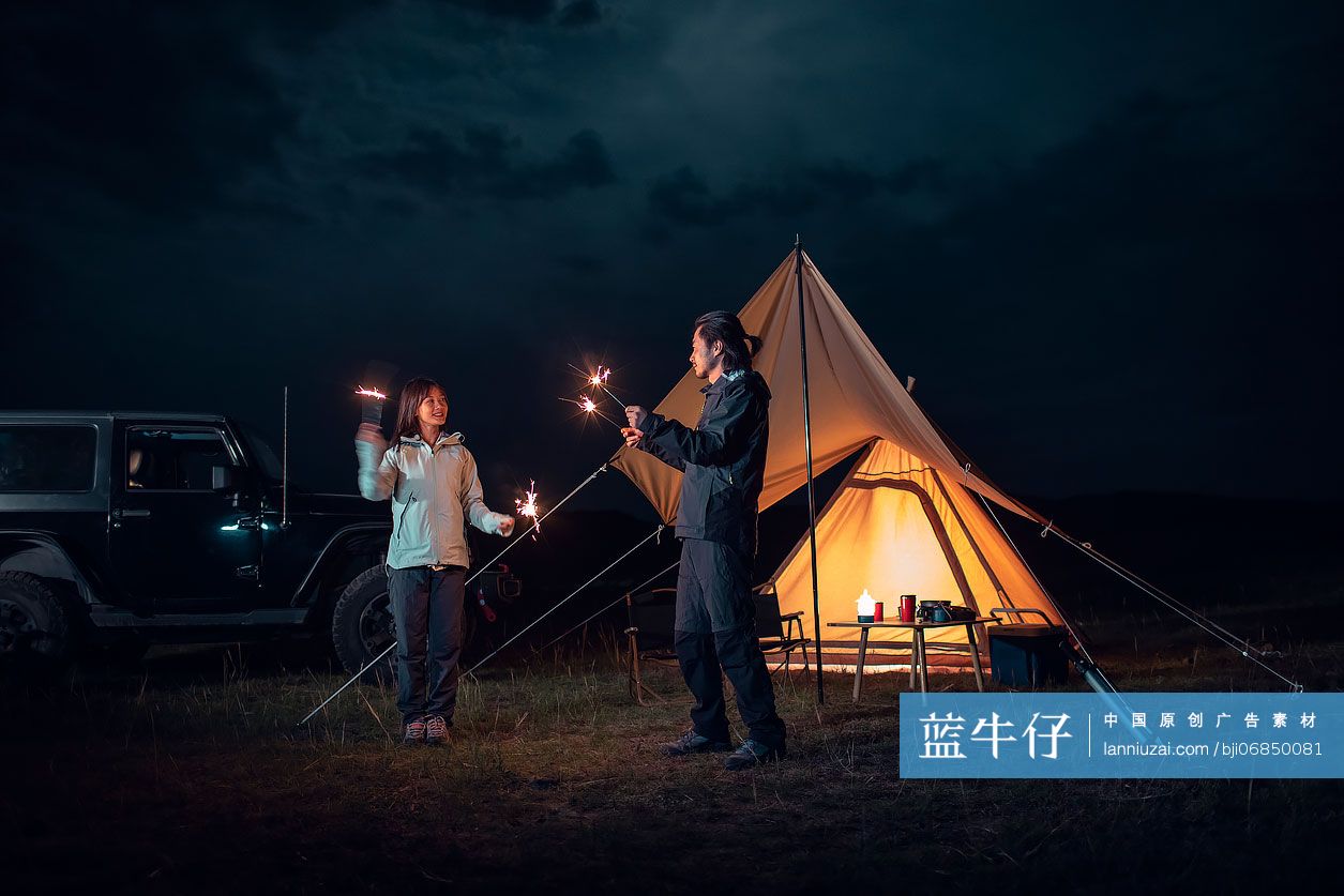 快乐的情侣户外露营放烟花