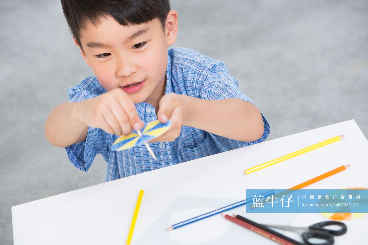 小男孩在做纸玩具