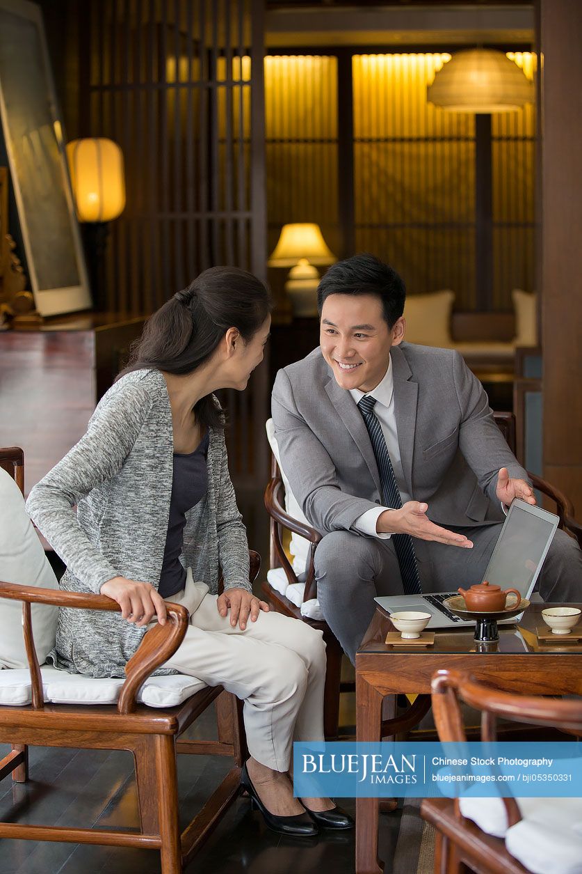 Confident Chinese financial consultant talking with a mature woman