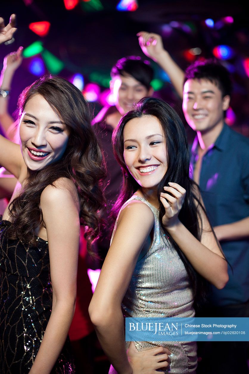 Stylish young Chinese dancing in nightclub