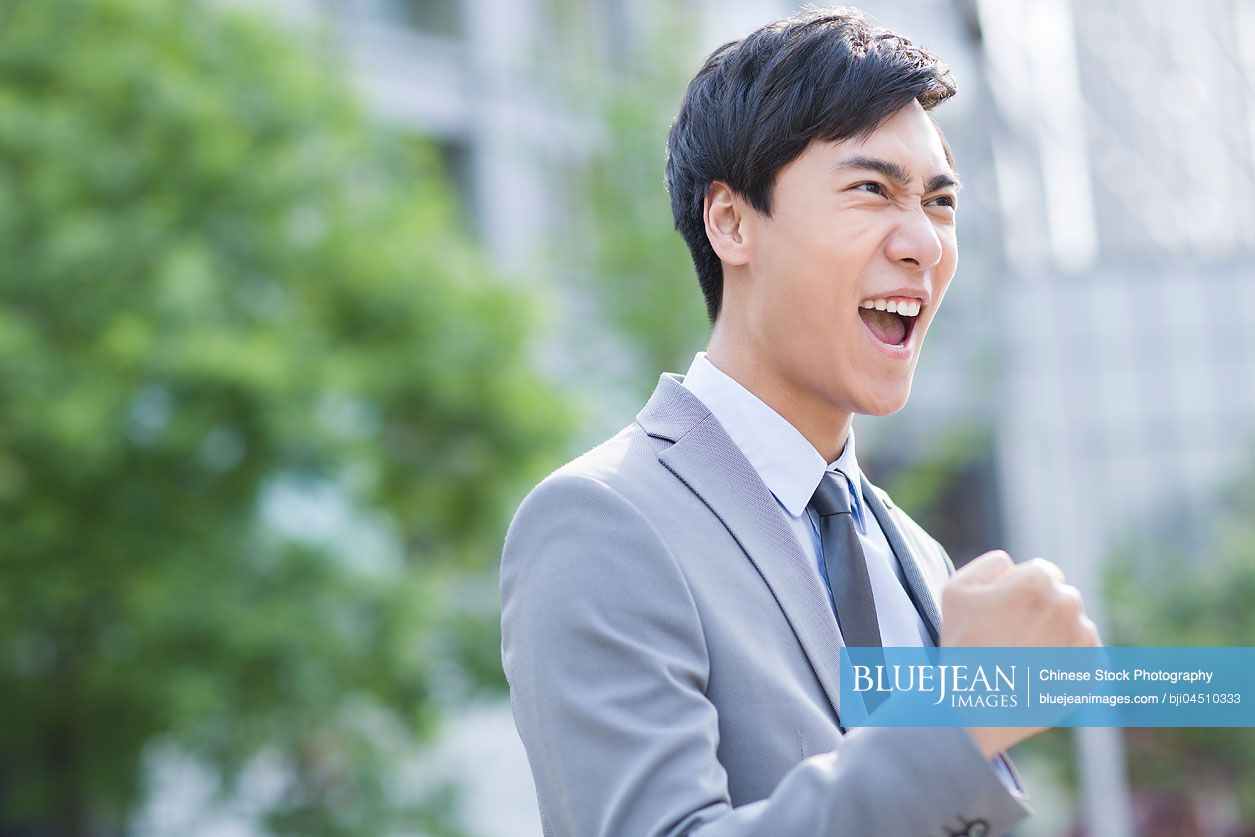 Young Chinese businessman cheering