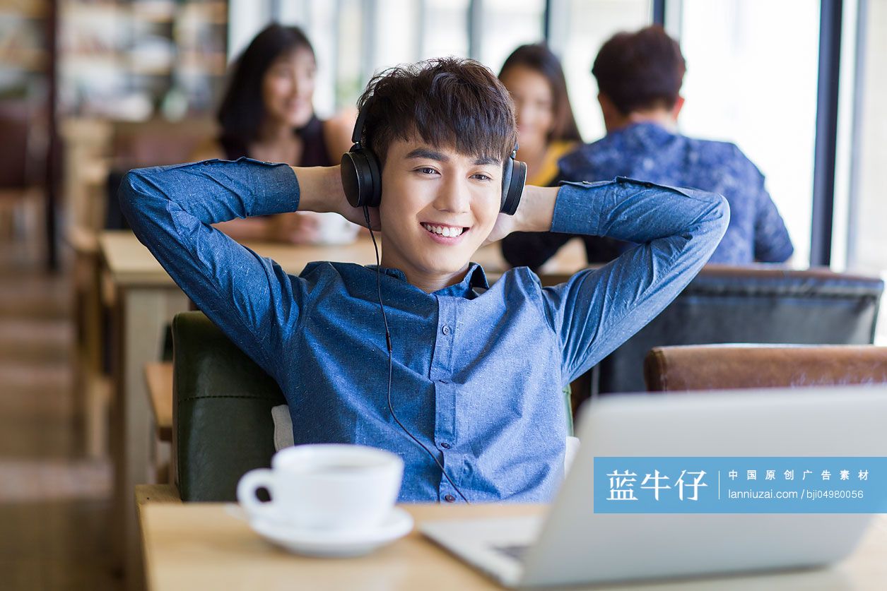 年轻男子在咖啡馆听音乐