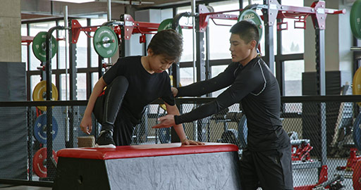 男孩在教练的指导下进行体能训练