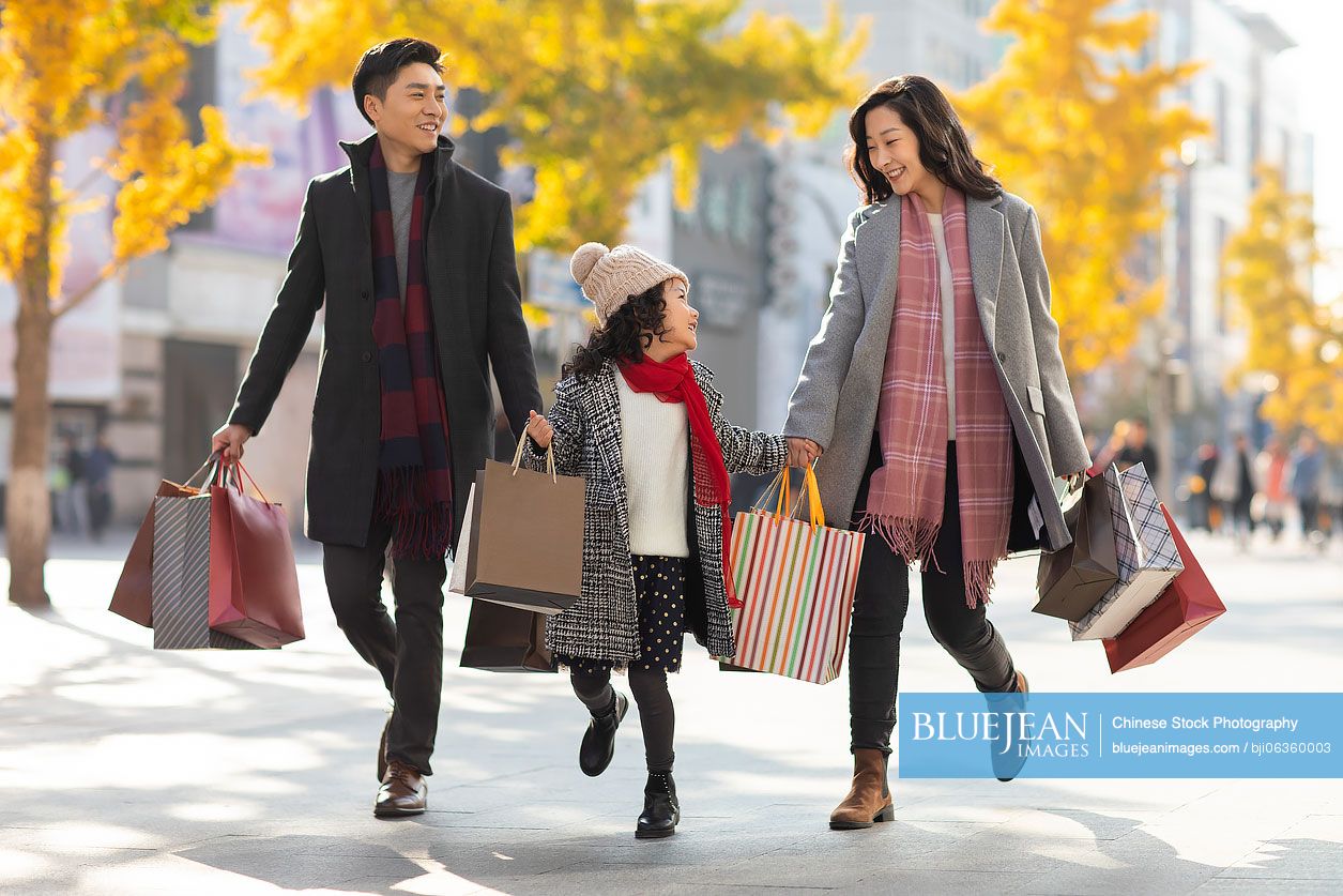 Happy young Chinese family shopping together