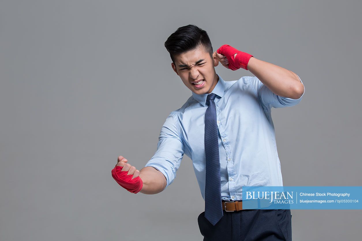 Young Chinese businessman punching