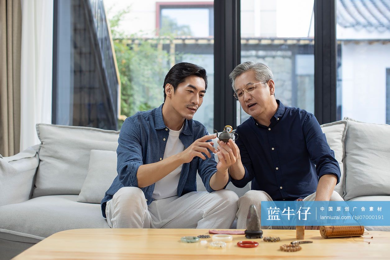 中年男子和父亲在家里鉴定古董