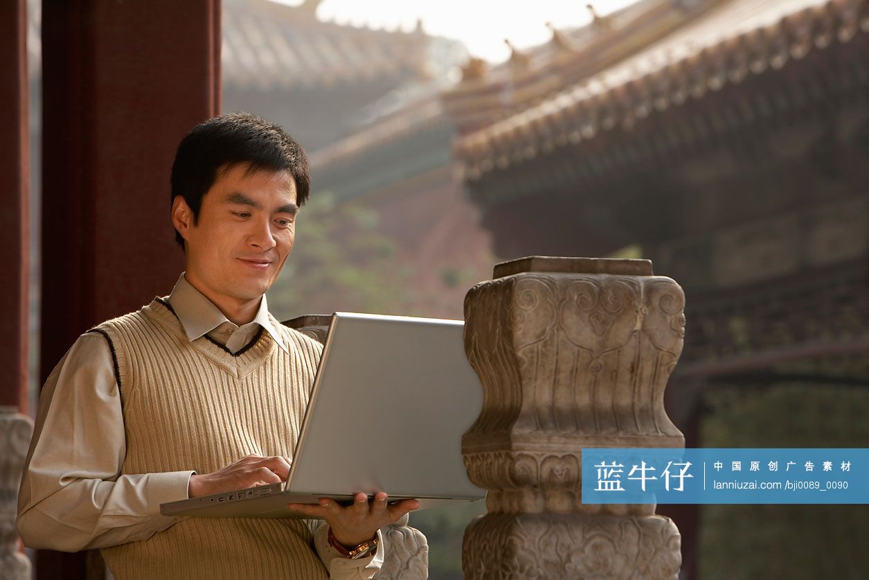 故宫里的商务男士使用笔记本电脑