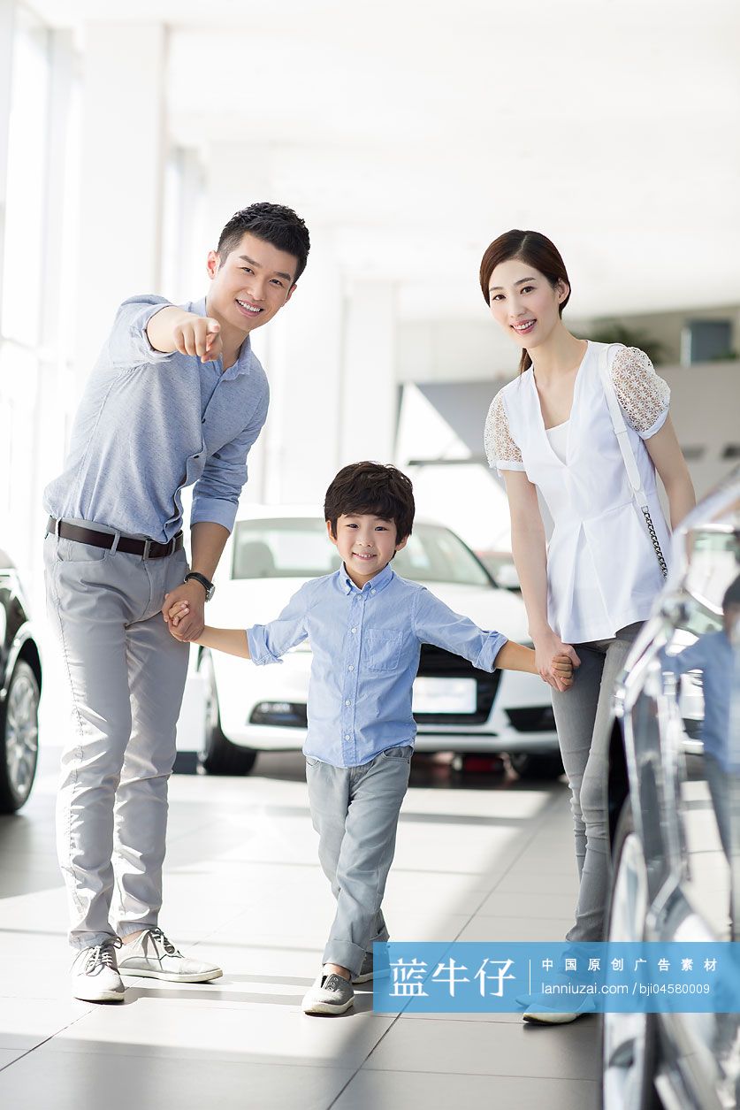 年轻家庭在4S店挑选汽车