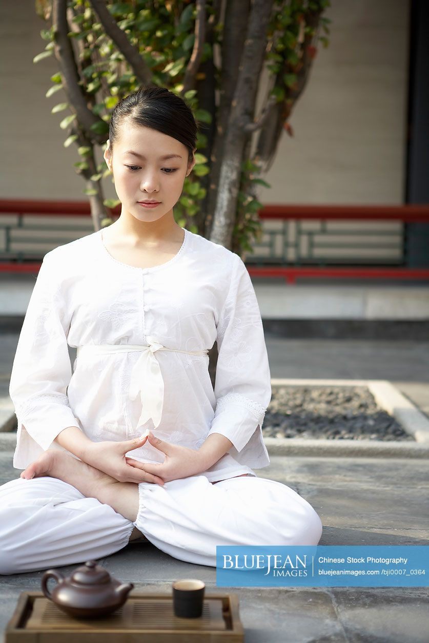 Chinese Woman Meditating Cross-legged Next To Tea Set
