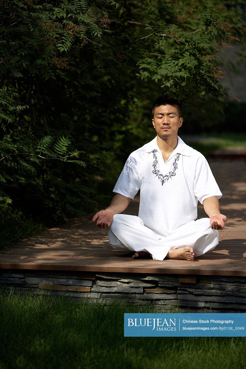 Chinese man meditating outdoors