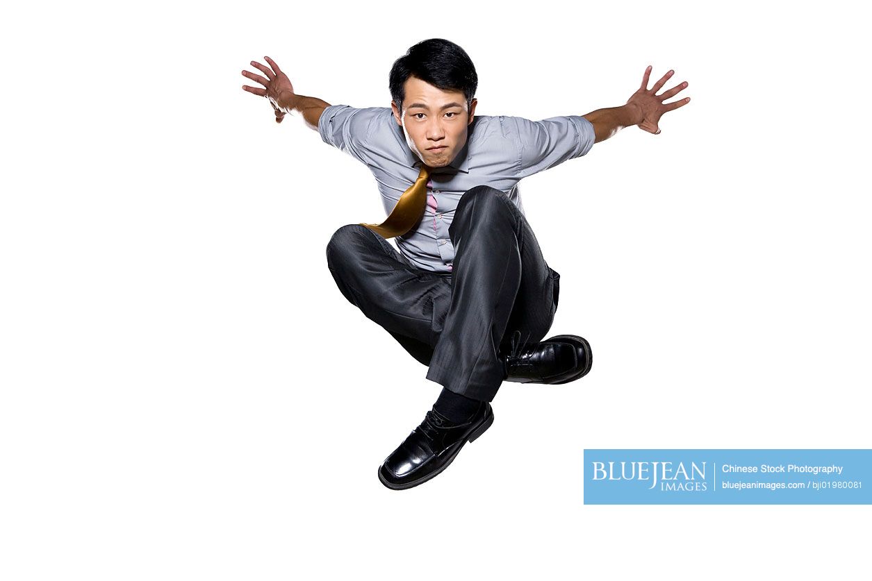 Chinese businessman jumping in mid air