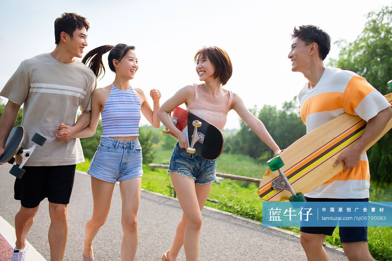 快乐的年轻人在公园玩滑板