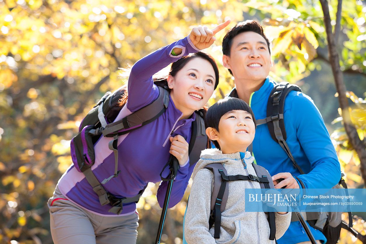 Happy Chinese family with back packs on a hike