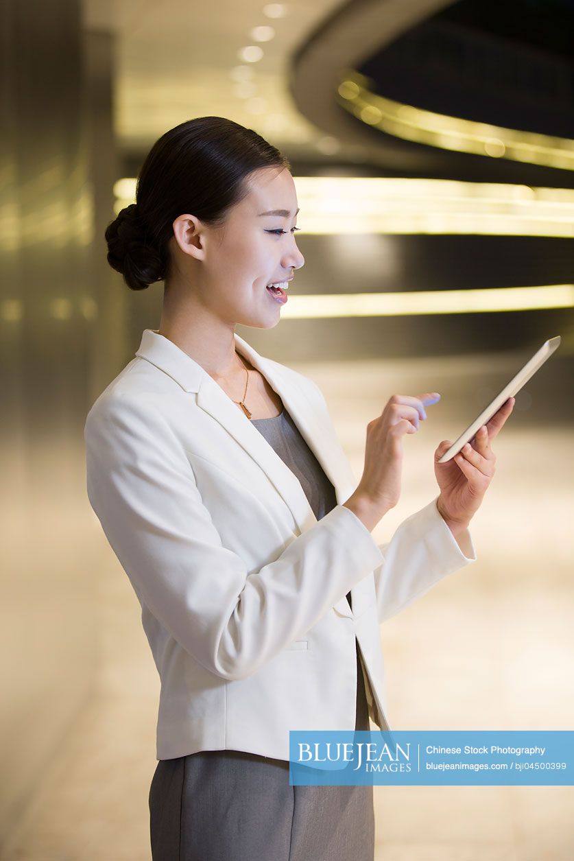 Chinese businesswoman using digital tablet outdoors