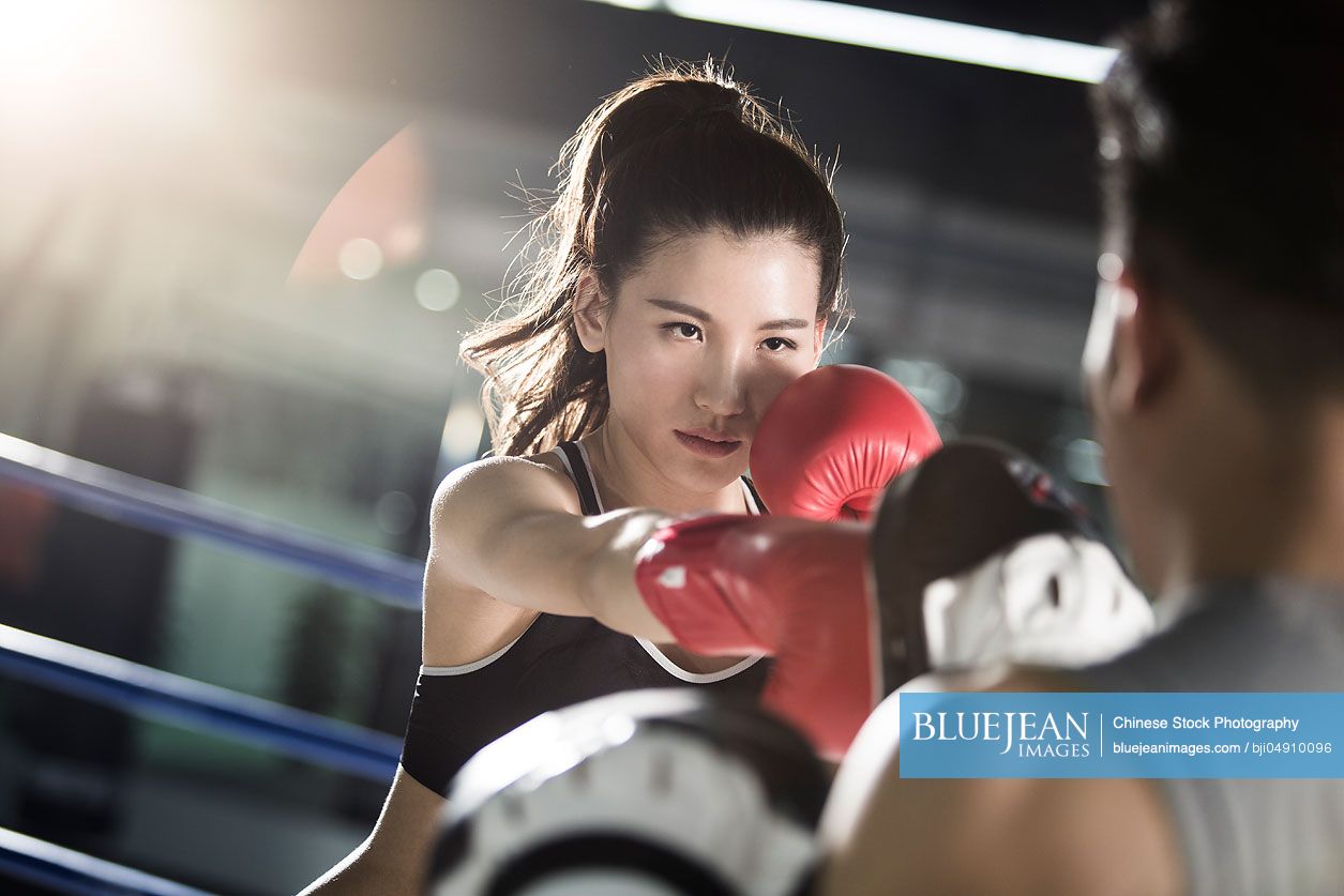 Female Chinese boxer training with coach