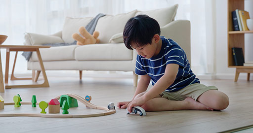 Happy little Chinese boy playing with toy train on floor,4K