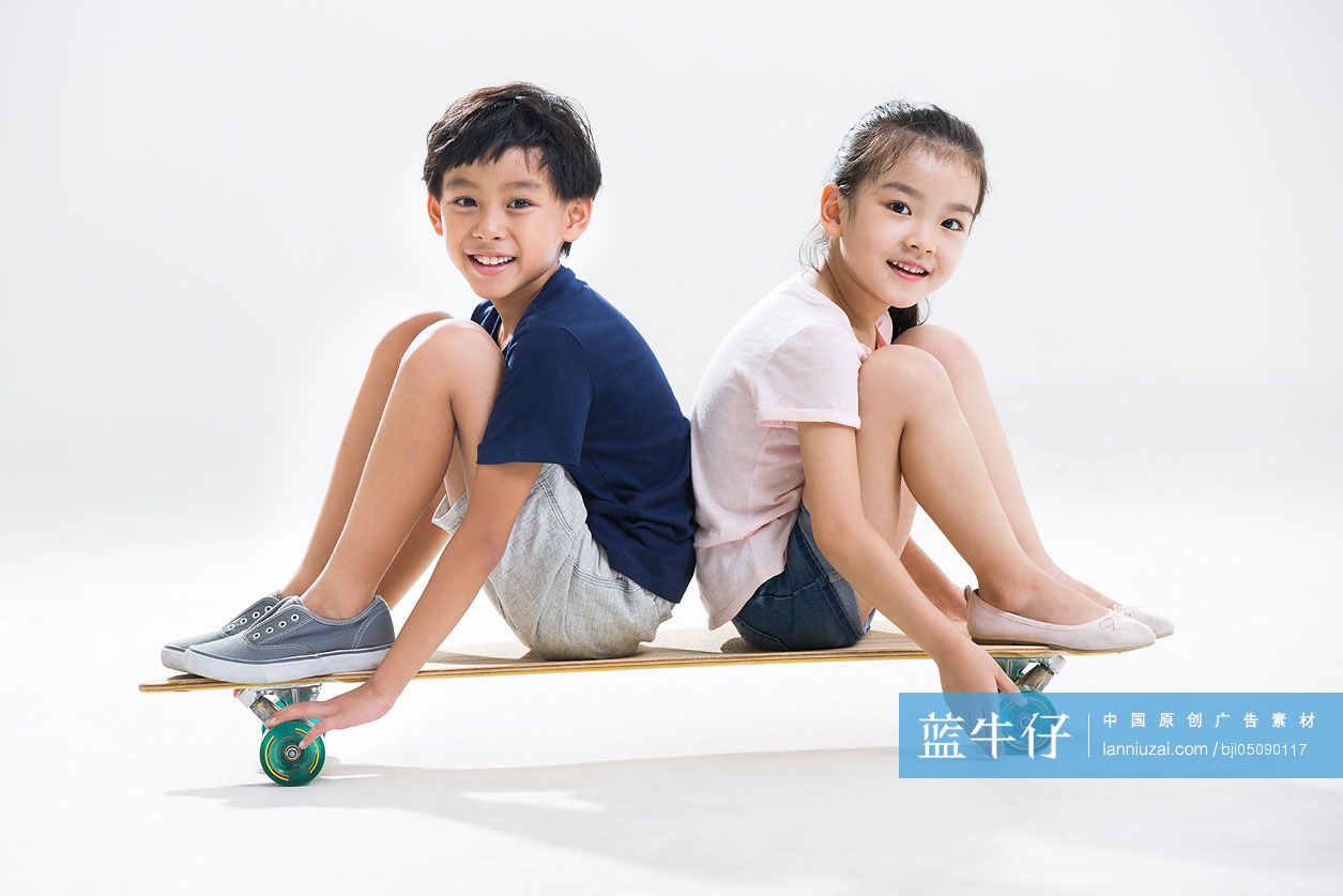 可爱的小男孩和小女孩玩滑板