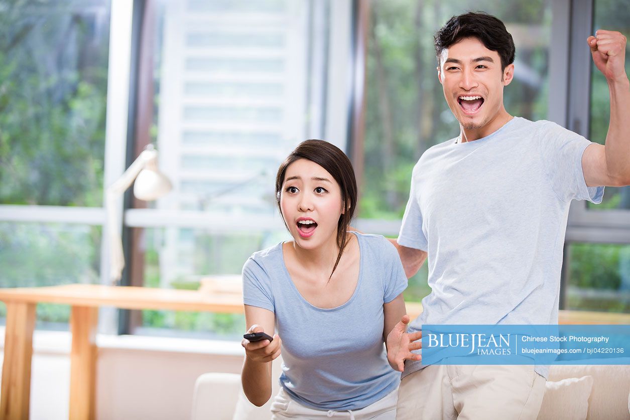 Young Chinese couple watching TV
