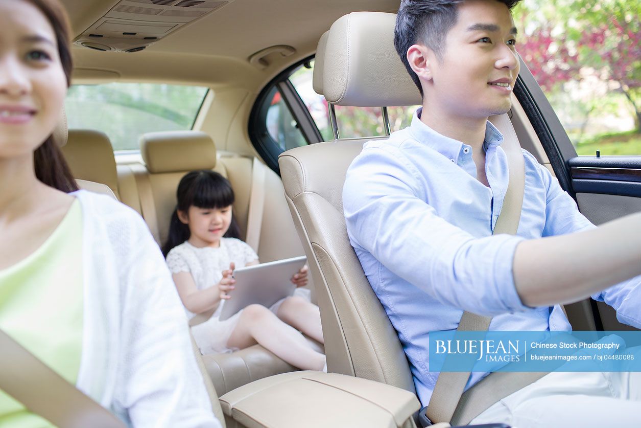Happy young Chinese family in a car