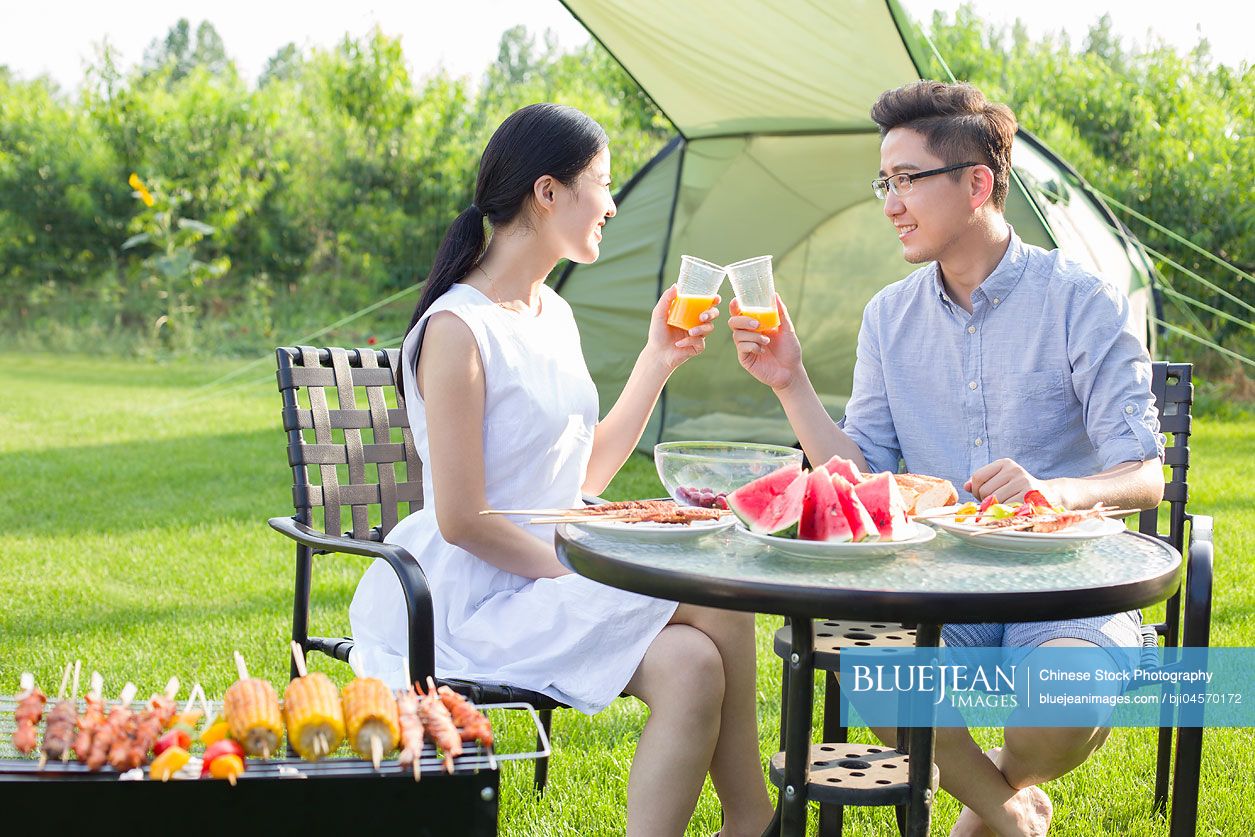 Young Chinese couple barbecuing outdoors