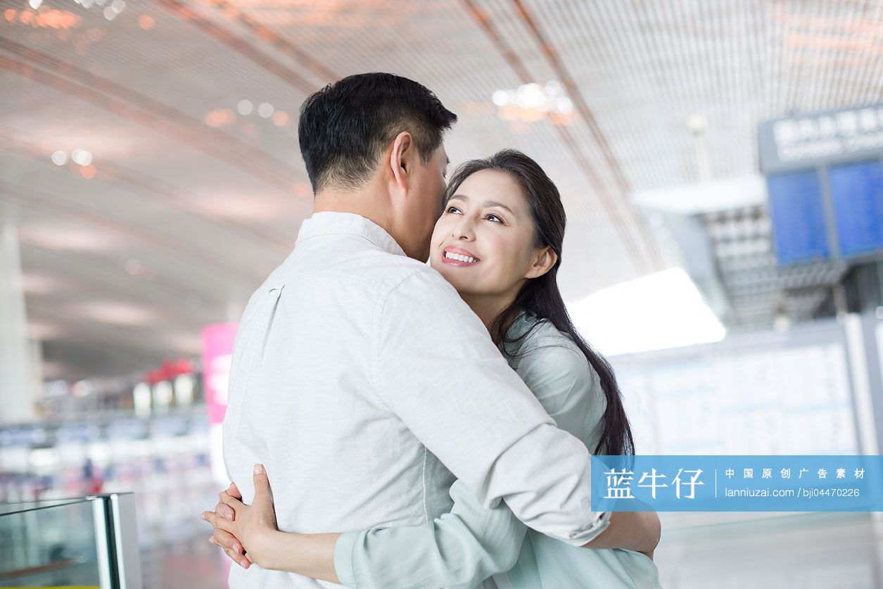 成熟中年夫妇在机场团聚拥抱