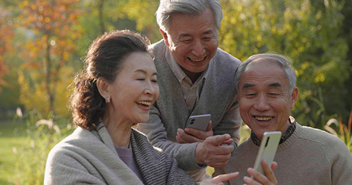 Cheerful senior Chinese adult using smart phones in the park,4K