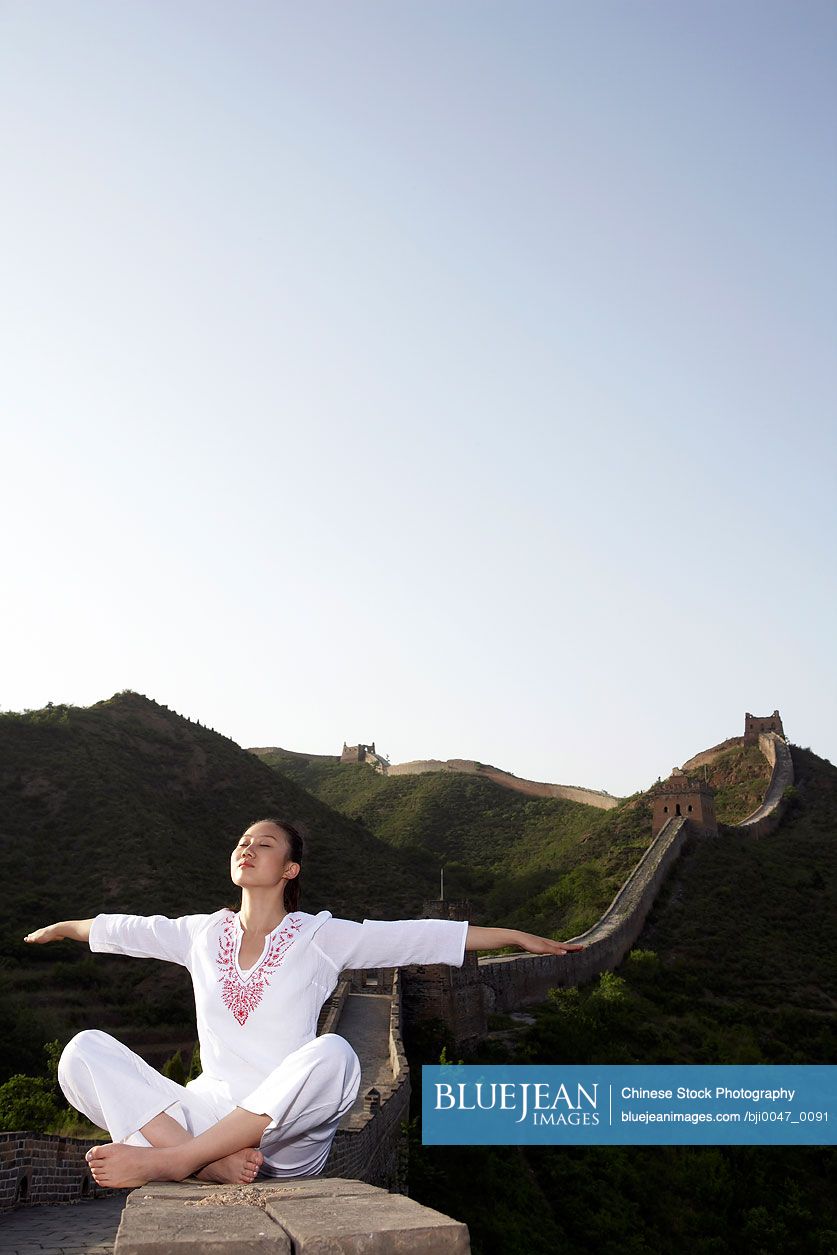Chinese Woman Doing Yoga On The Great Wall Of China