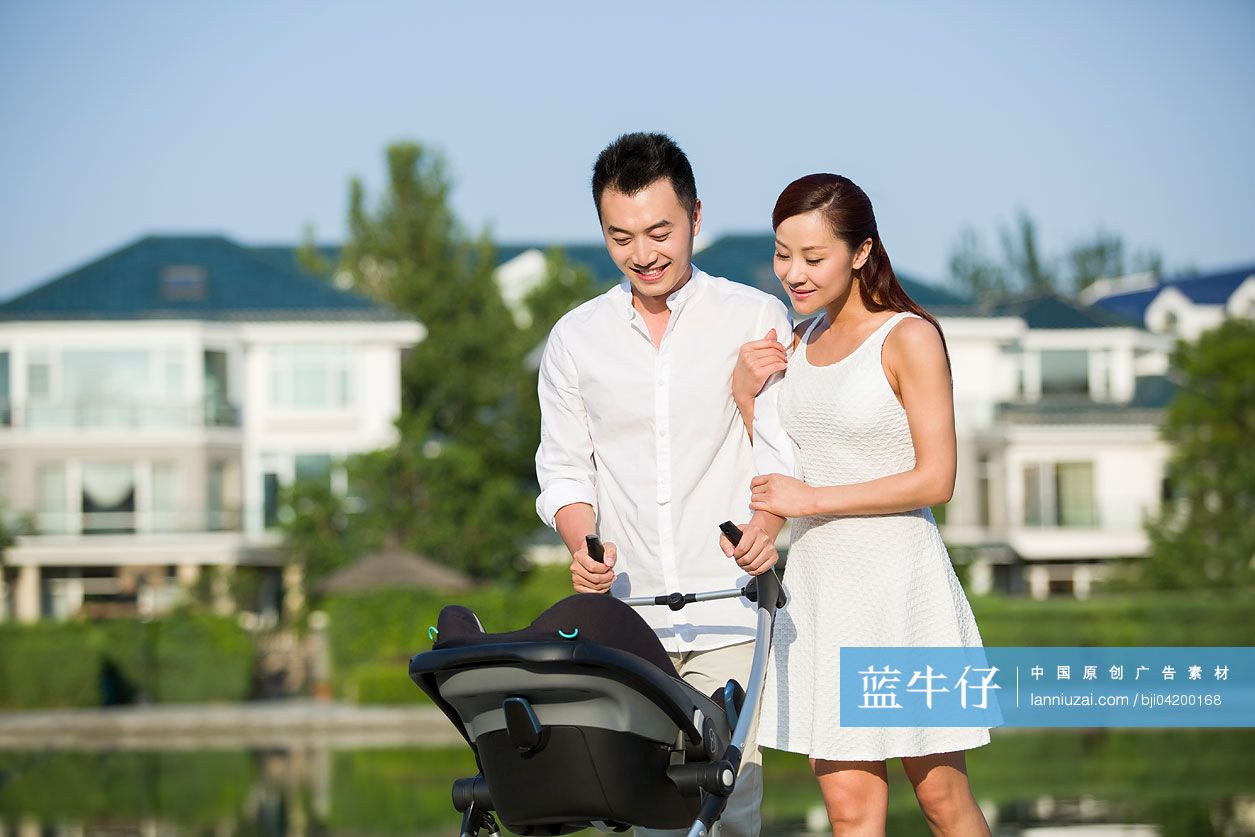 年轻情侣推着婴儿车散步