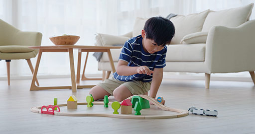 Happy little Chinese boy playing with toy train on floor,4K