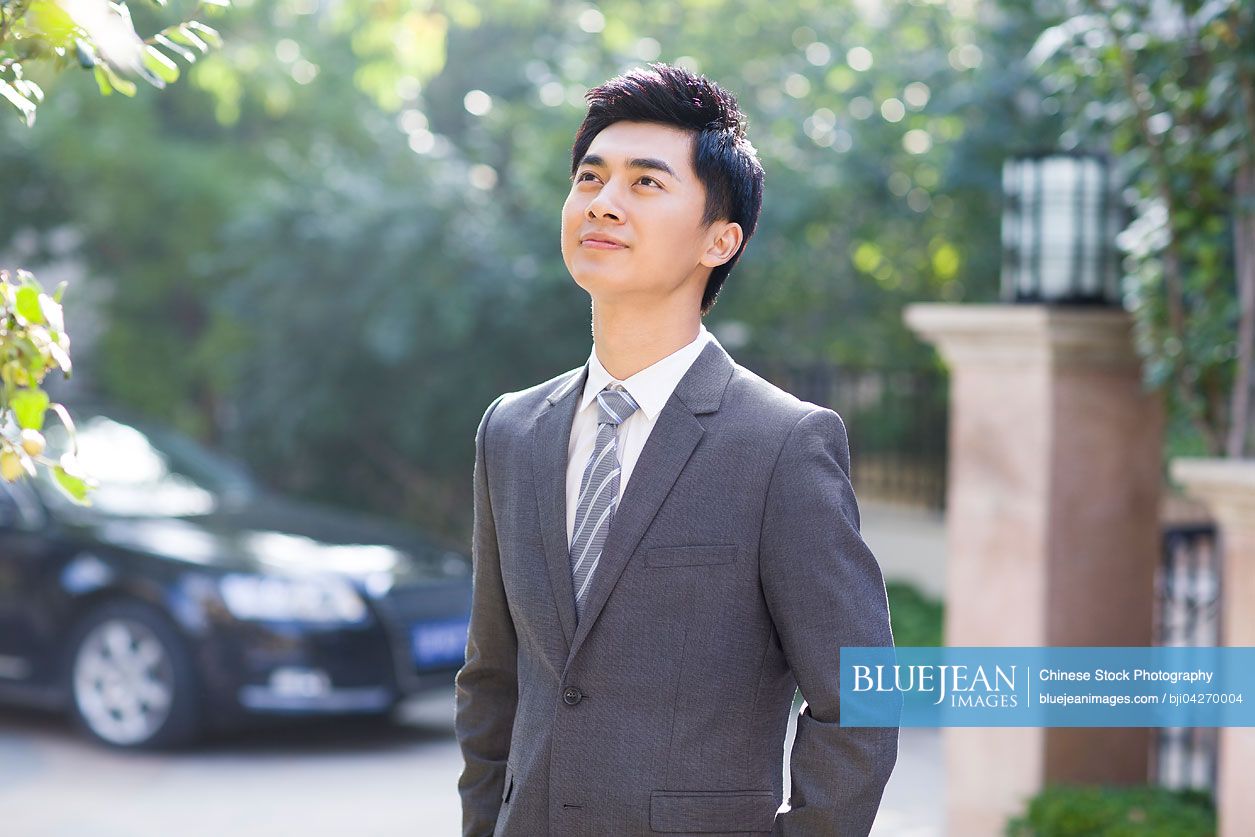 Young Chinese businessman looking up