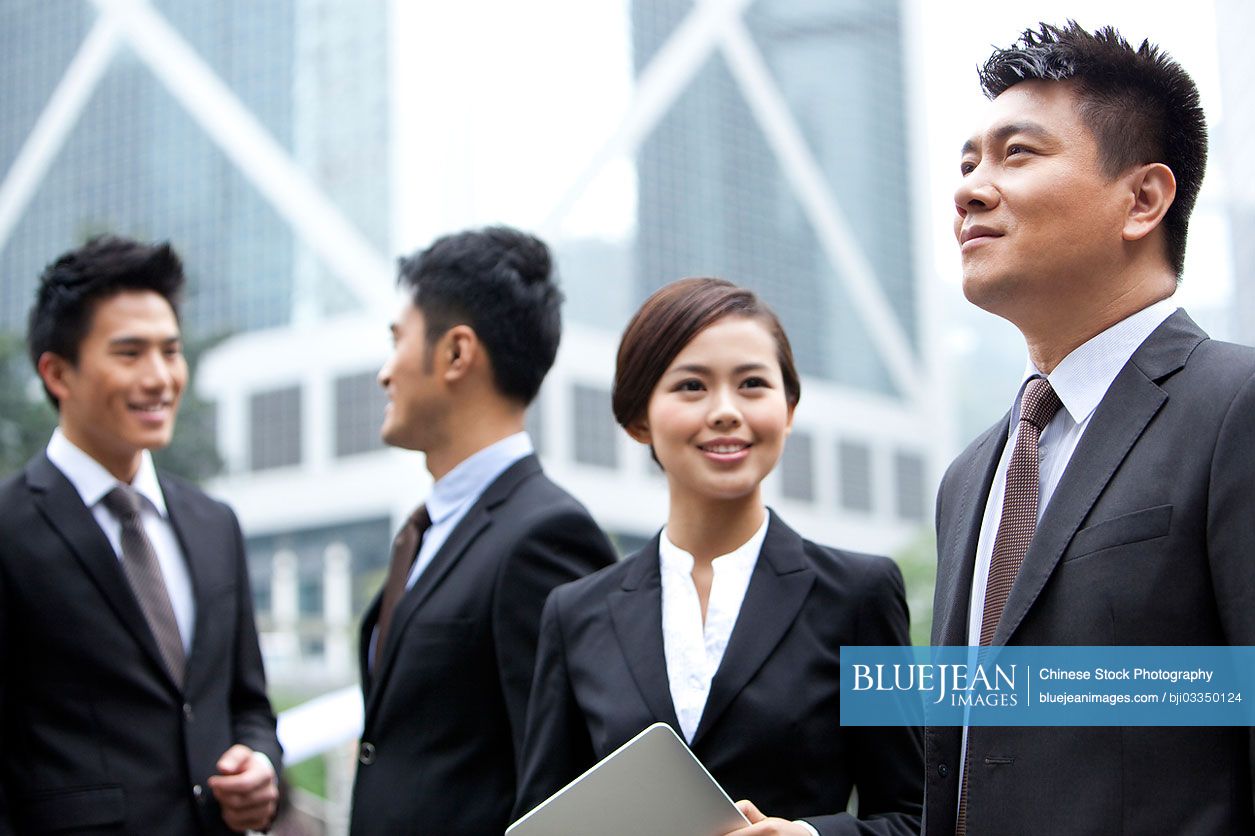 Cheerful Chinese businesswoman with her team in Hong Kong